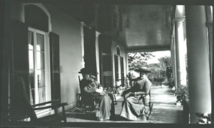 Miss Sue Williams, model for Mary Bayly, on porch with guest, 1910